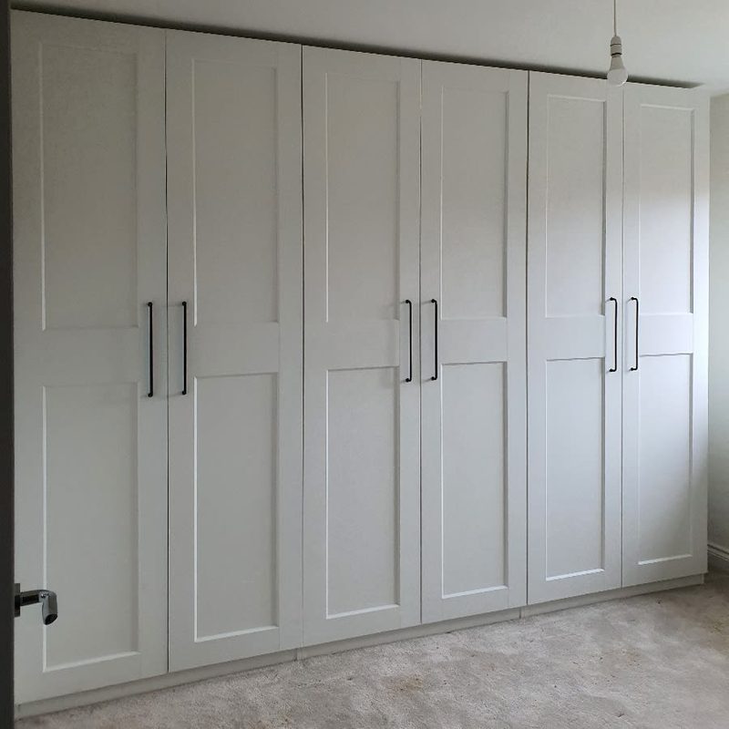 Wall-to-wall white IKEA PAX wardrobe with black handles assembled in Manchester