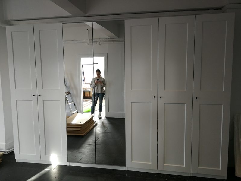 Large white IKEA PAX wardrobe with center mirror panels professionally assembled